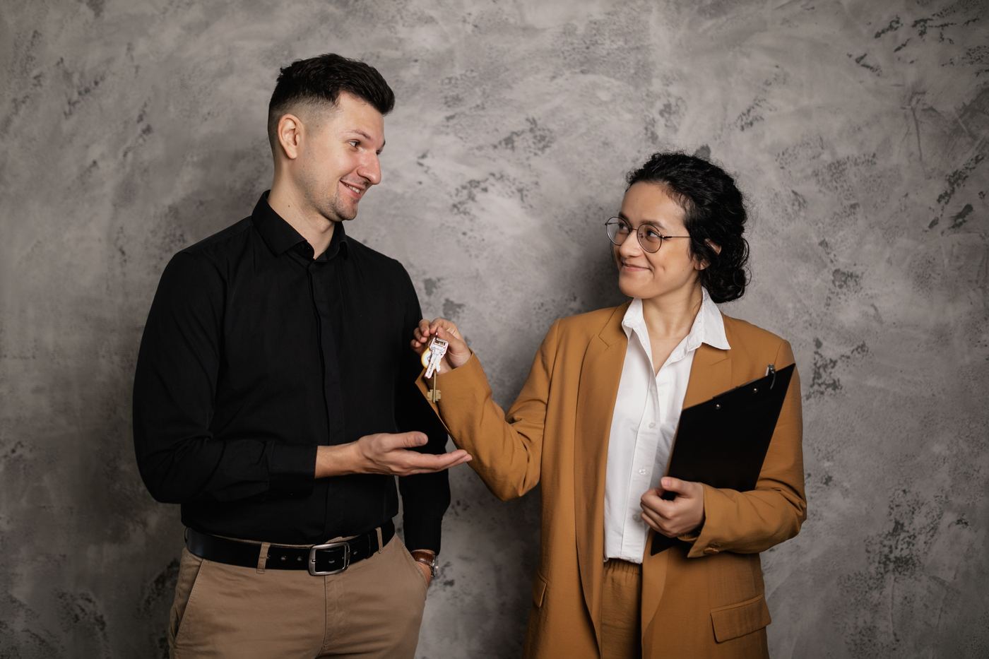 Real estate agent handing over house keys to a buyer, representing being fully underwritten and ready to close on a home in Castaic, Santa Clarita.