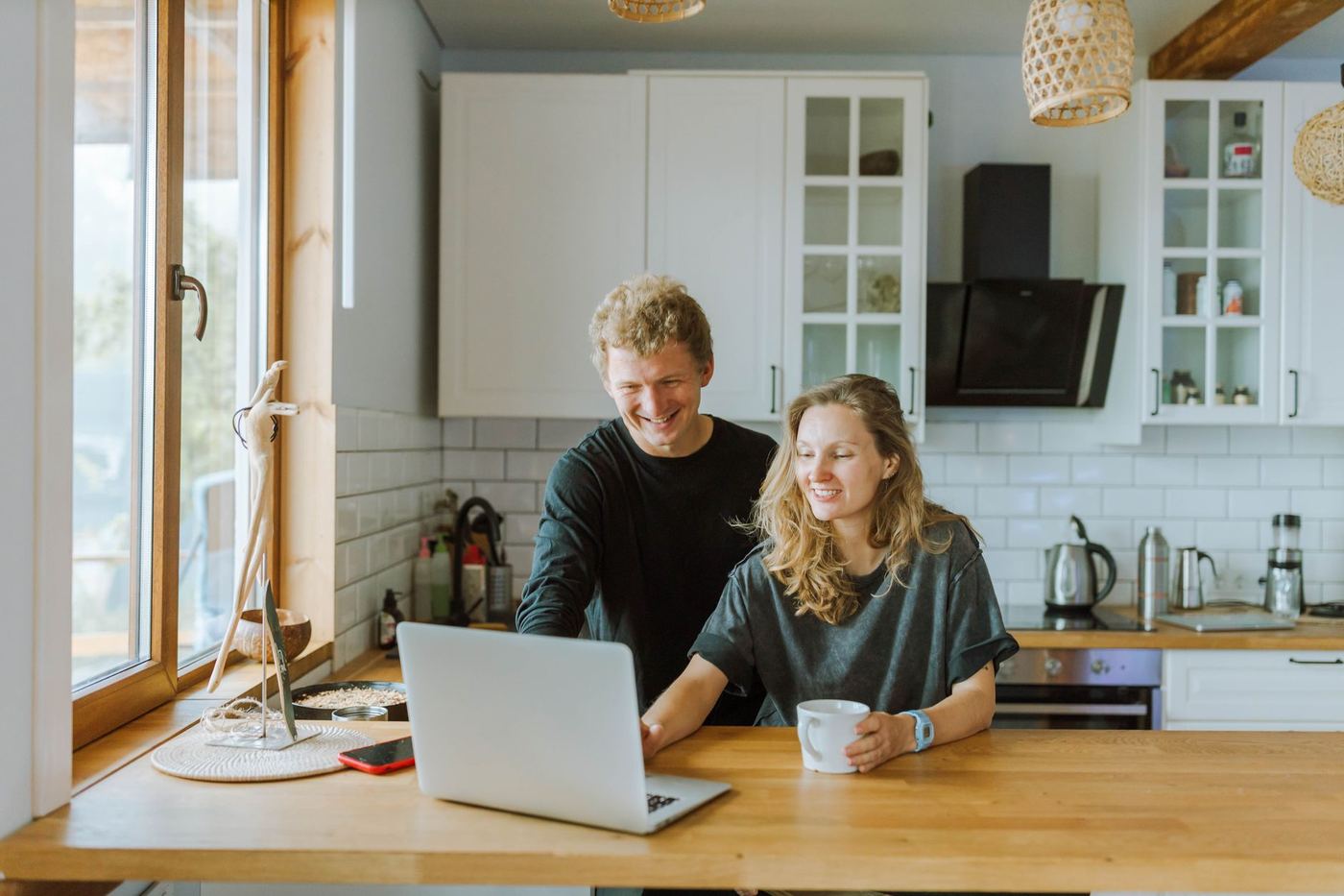 Couple reviewing mortgage rate numbers together on a laptop at their kitchen table, Santa Clarita home buyers checking this week's rates