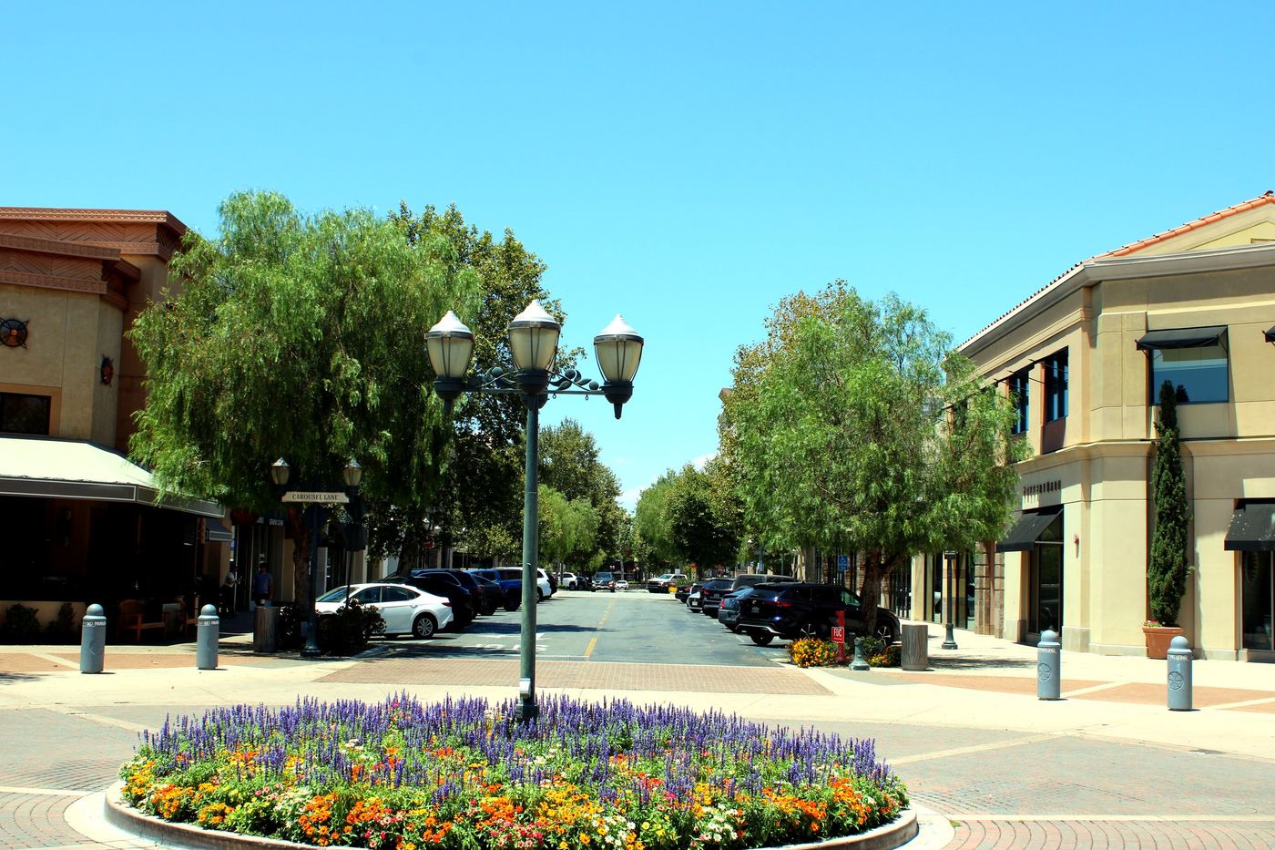 Wide walkway view of Valencia Town Center in Valencia, Santa Clarita, with palm trees and storefronts